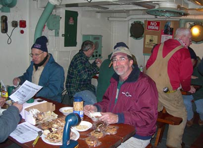 Volunteers break for lunch in LV-112's galley